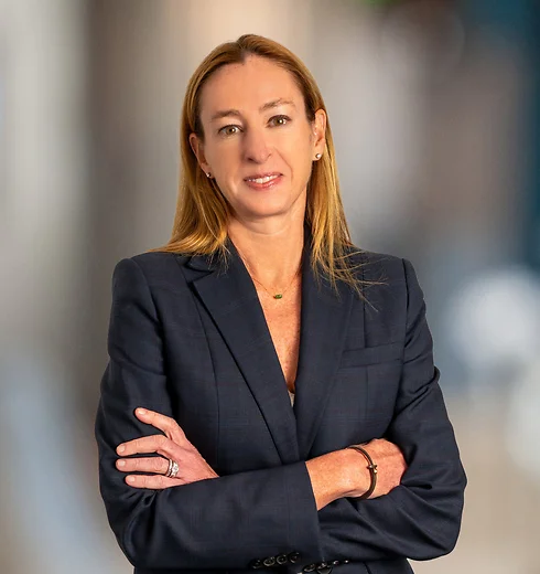 Nicole Harrell in a dark suit with her arms crossed