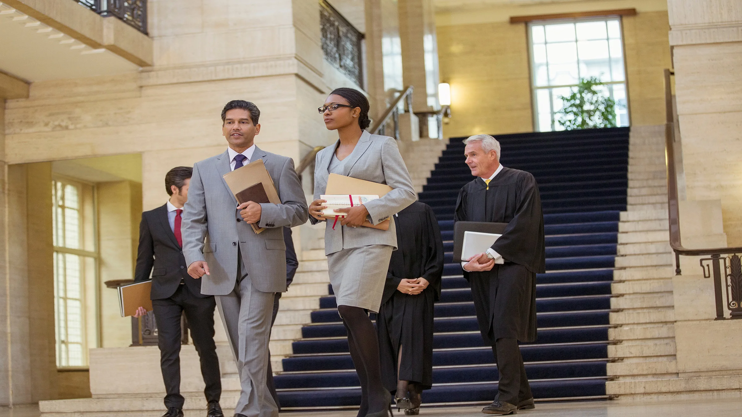 Business people in suits walking across a lobby
