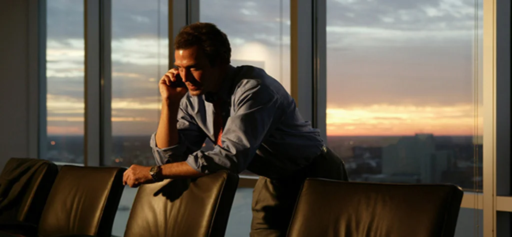 Man in an empty conference room on phone
