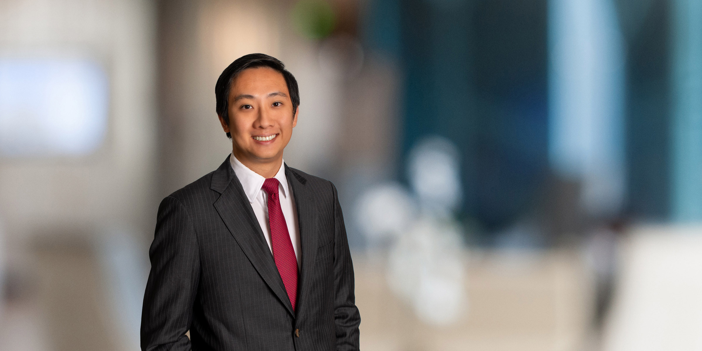 Benny Zhang in a dark suit and red tie