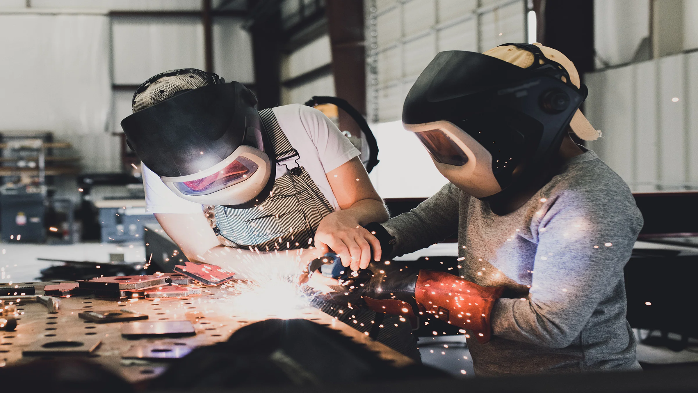 2 people with masks on welding