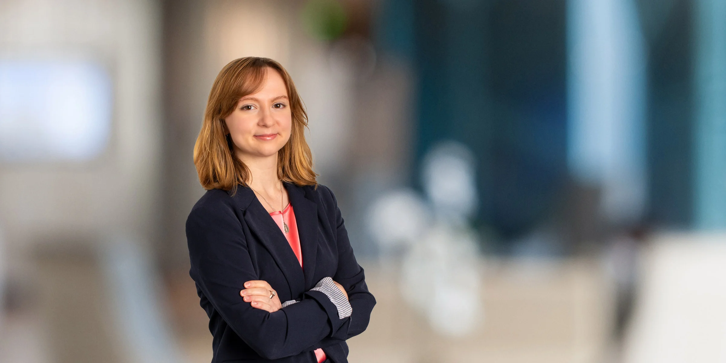 Savannah Kimble smiling in a pink shirt and suit jacket with her arms crossed