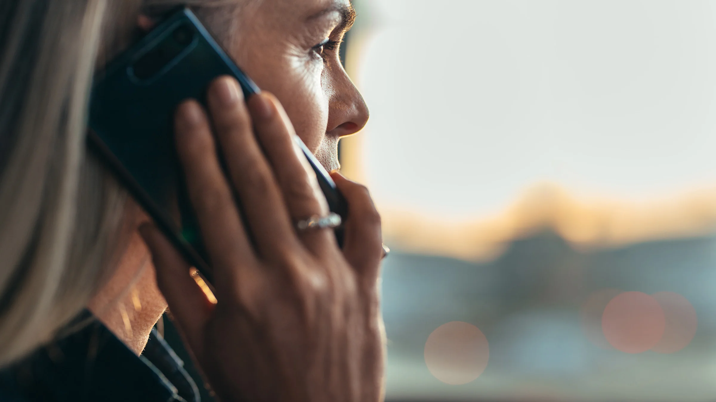 Blond woman on phone looking out window