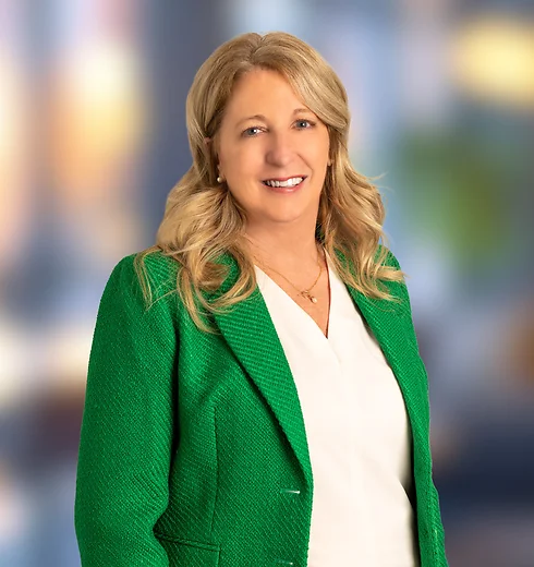 Shirley Beacham in blue jacket and printed blouse.