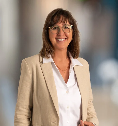 Laurie Flowers in tan jacket with white blouse.