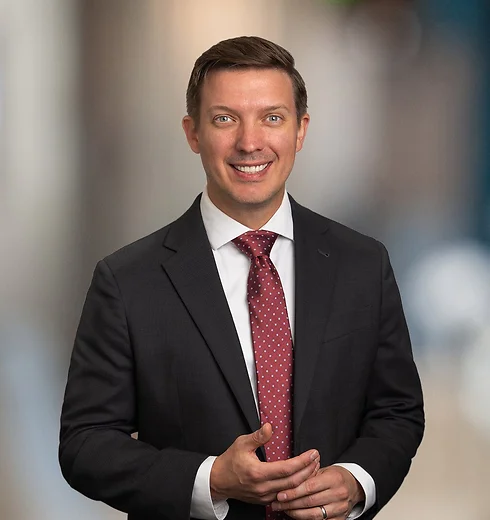 Ben Wills in a black suit and red tie