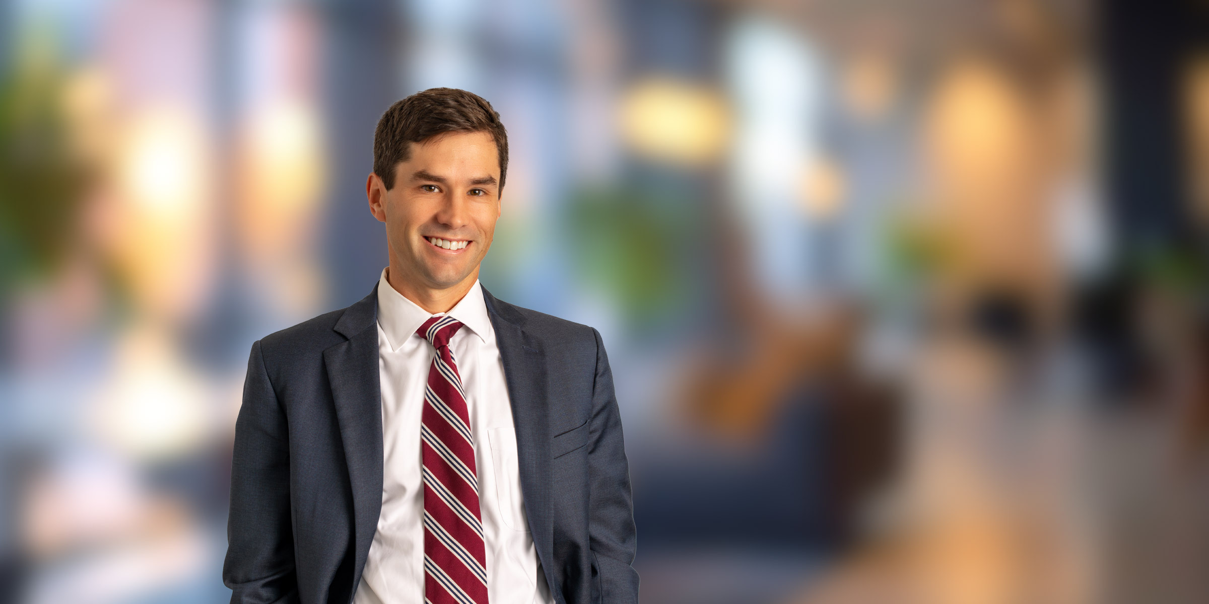 Clark Belote in a suit with his hands in his pockets
