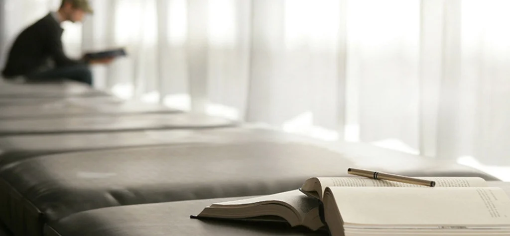 Man on bench reading in background