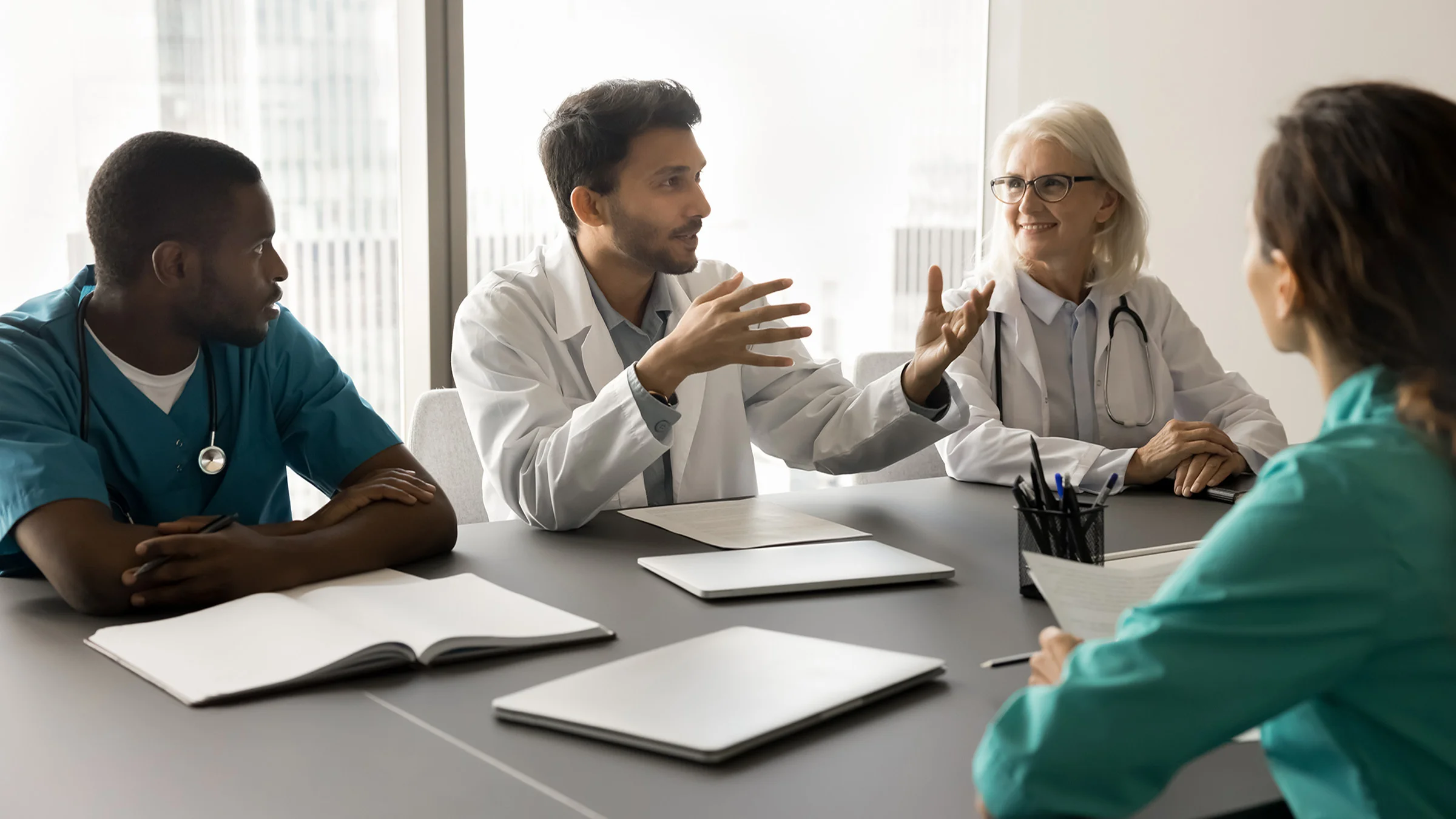 4 doctors in a meeting around a table