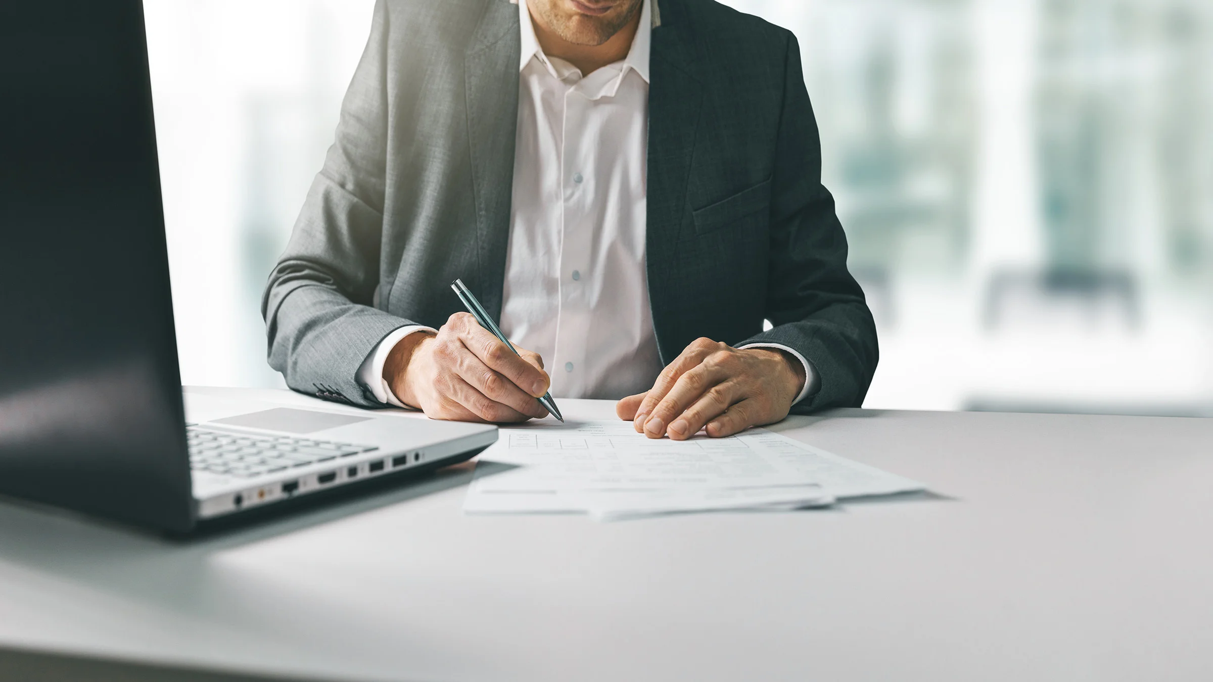Man at desk writing on paper