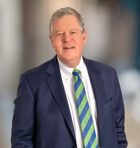 Charles McPhillips in a navy suit and green and blue striped tie