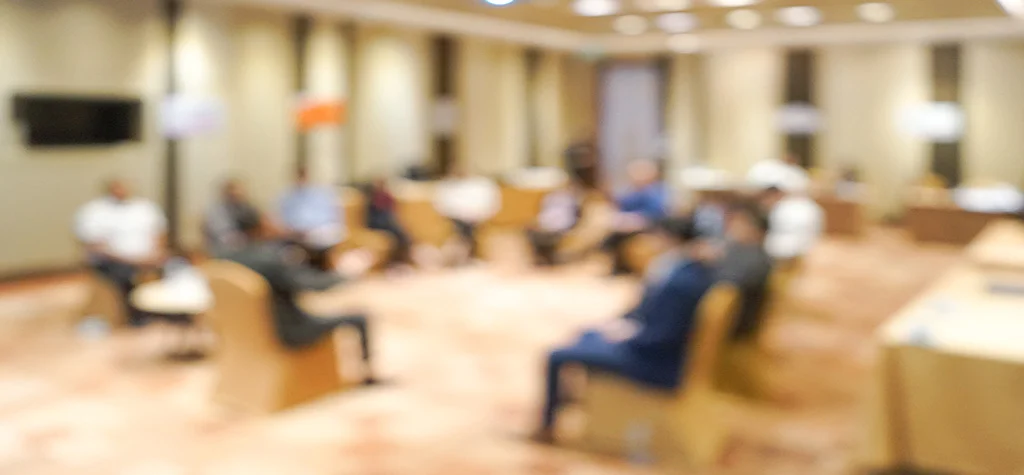 Blurry people sitting around a circle