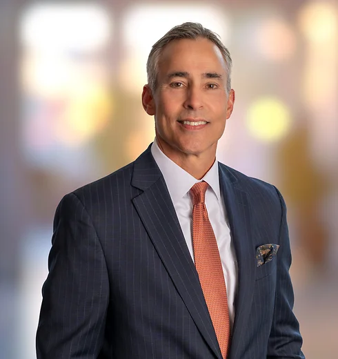 Mark Short in a dark suit and orange tie