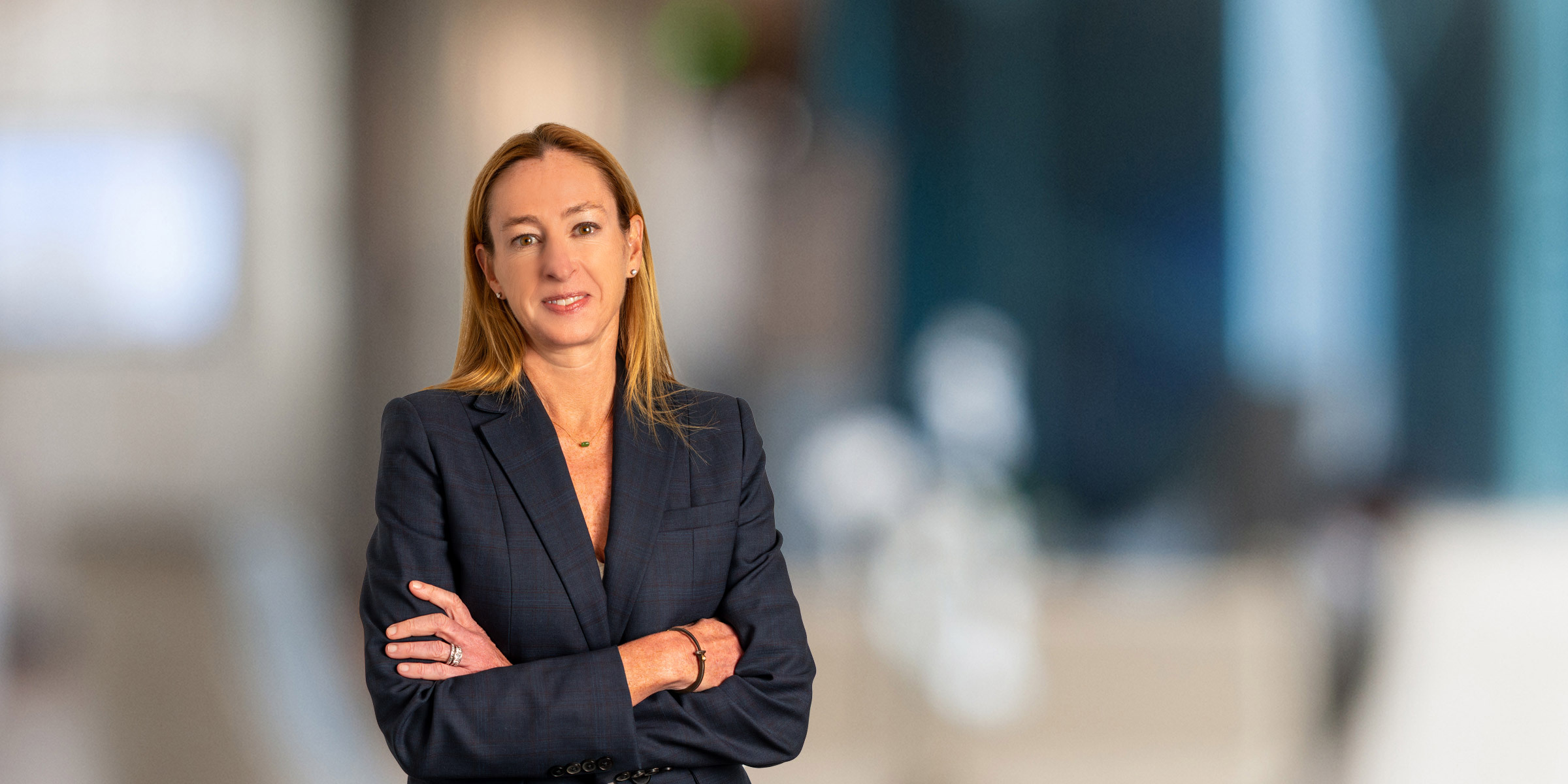 Nicole Harrell in a dark suit with her arms crossed