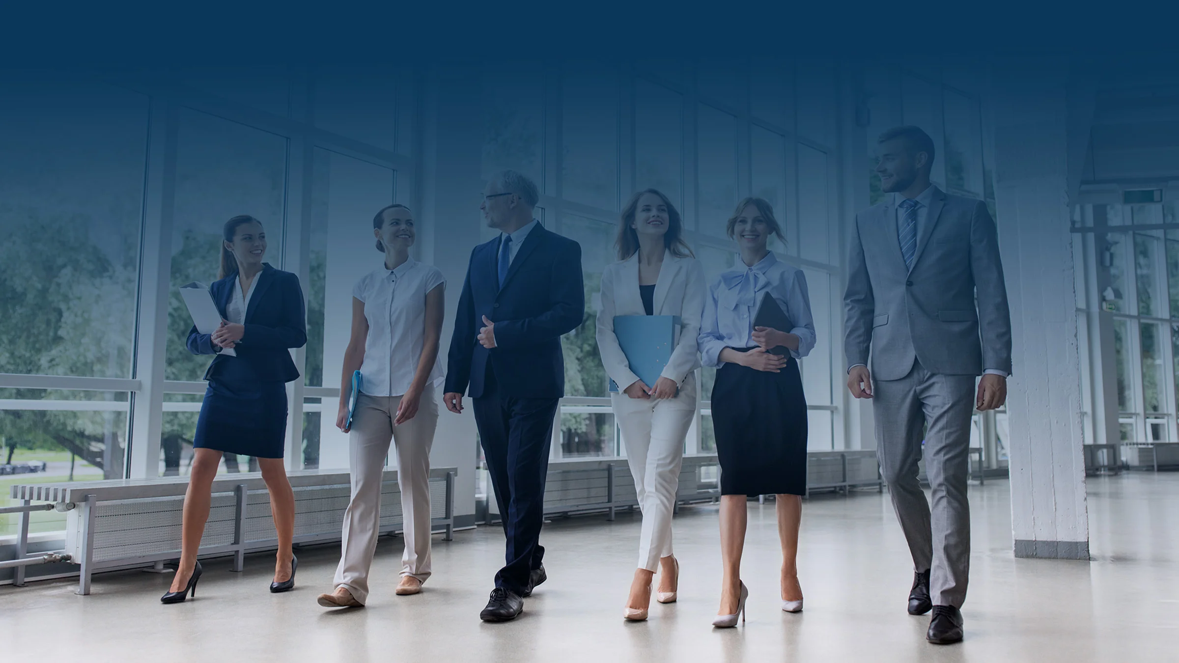 Groupd of people walking in an office with a blue gradient at the top