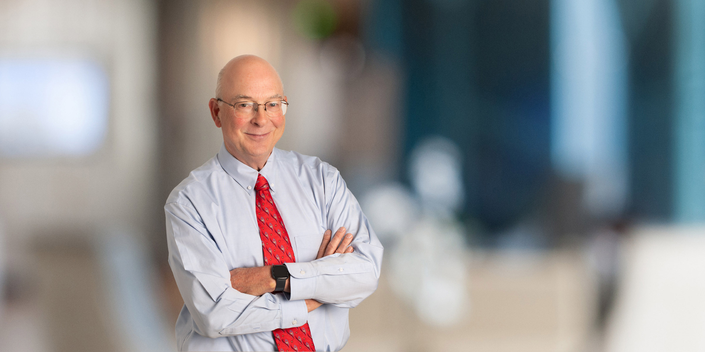 Steve Story wearing a light blue shirt and red tie