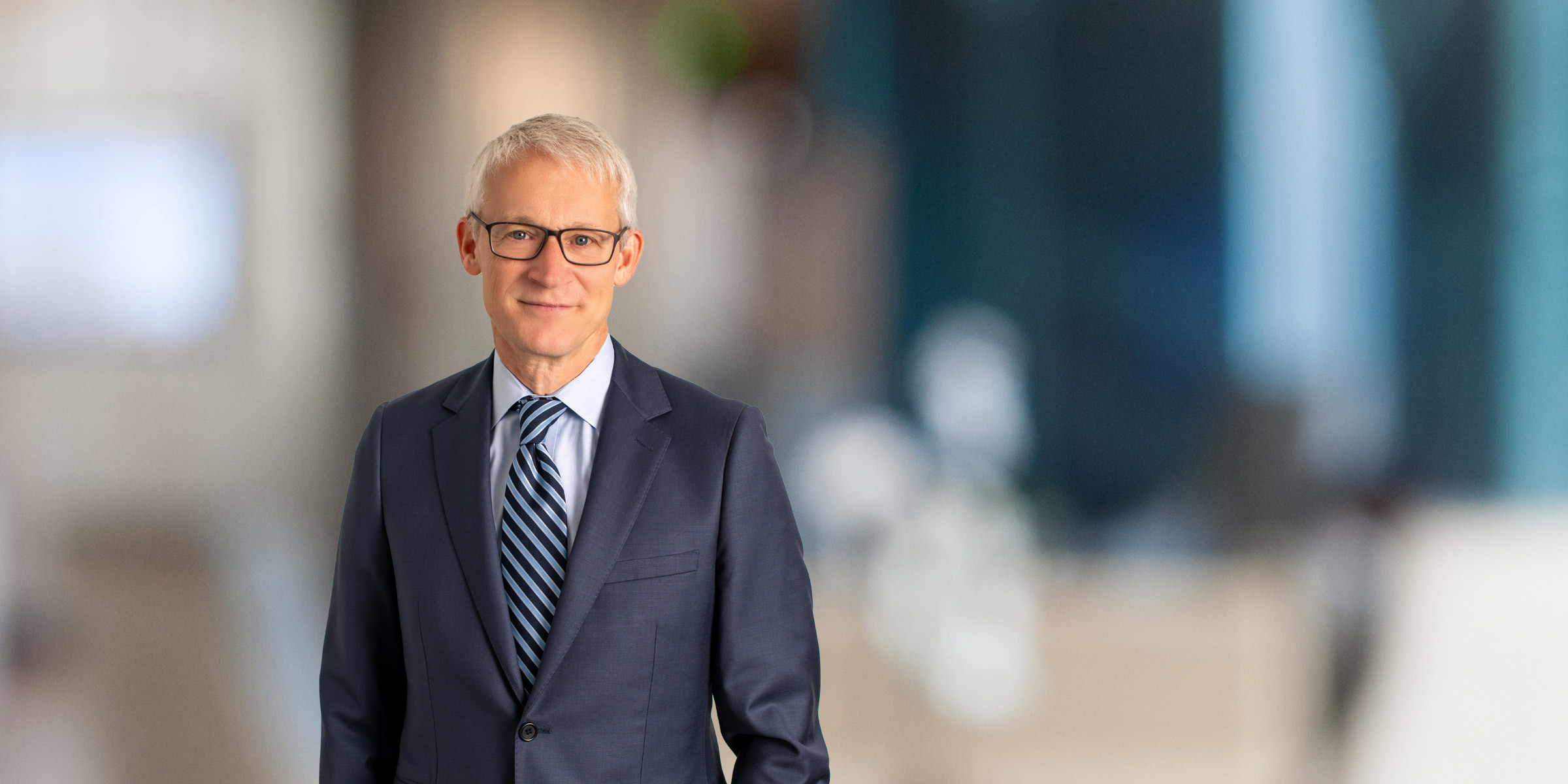Jason Davis in navy suit and striped tie