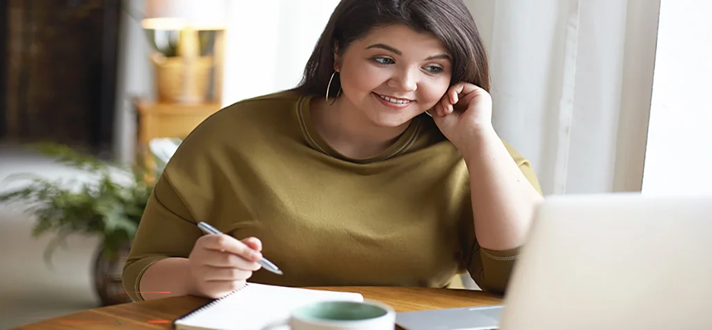 Smiling woman writing in notebook