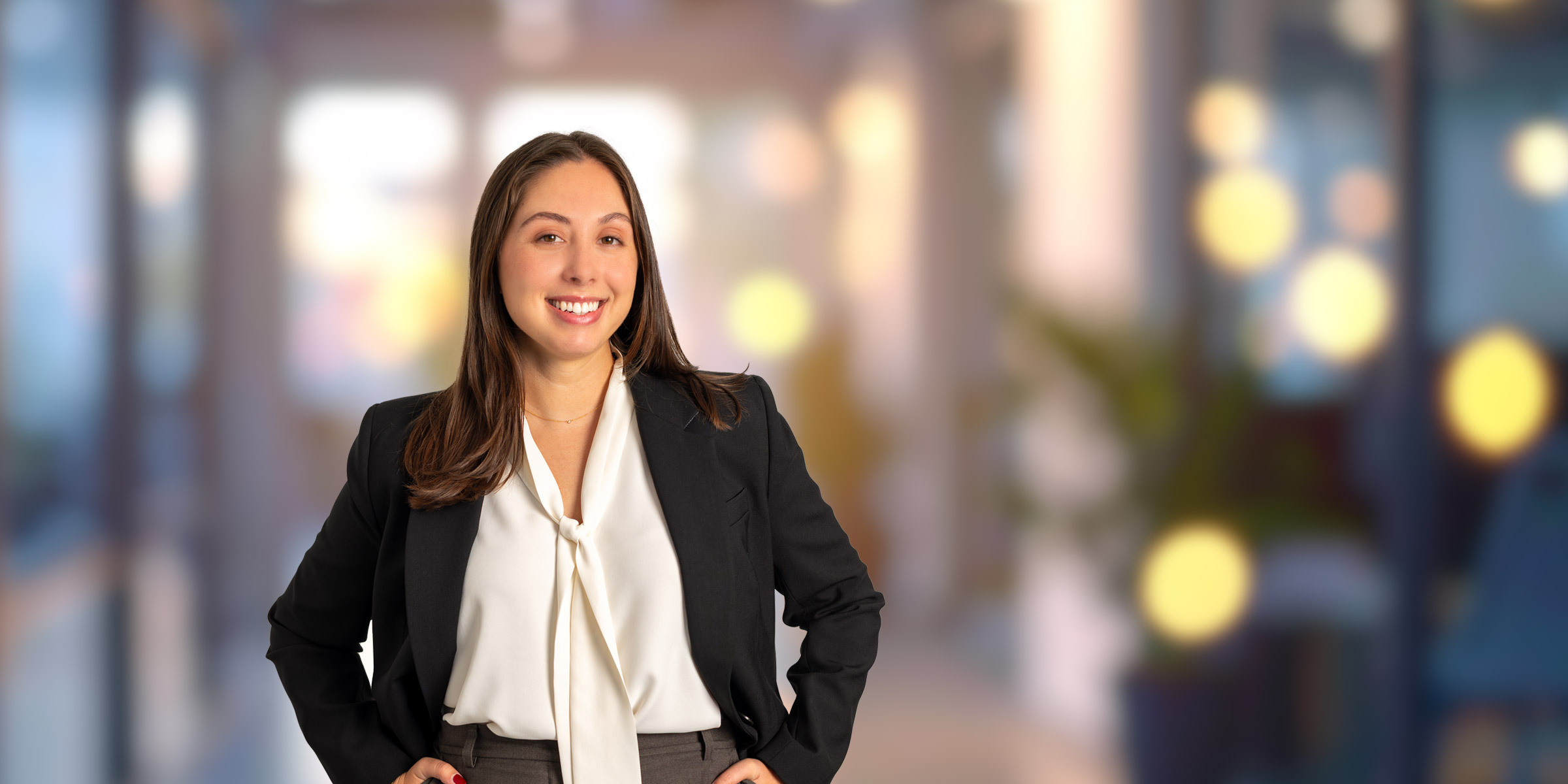 Maeve Harris in a suit with her hands on her hips