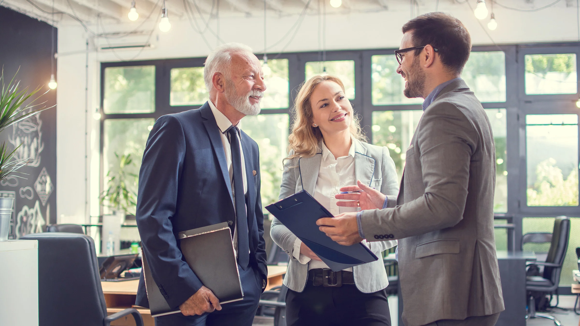 3 business people standing in a conference room