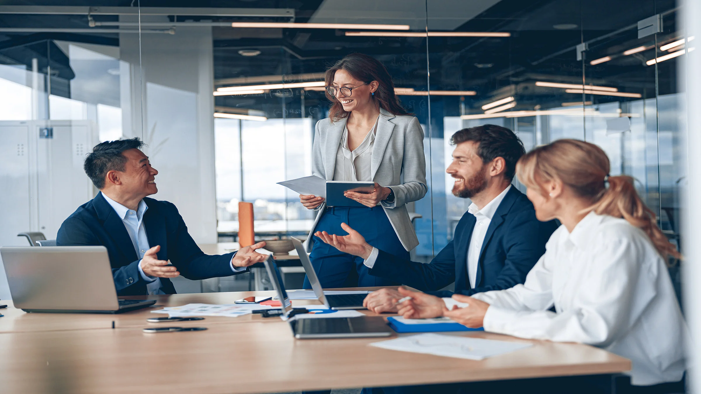 4 smiling people around a meeting table