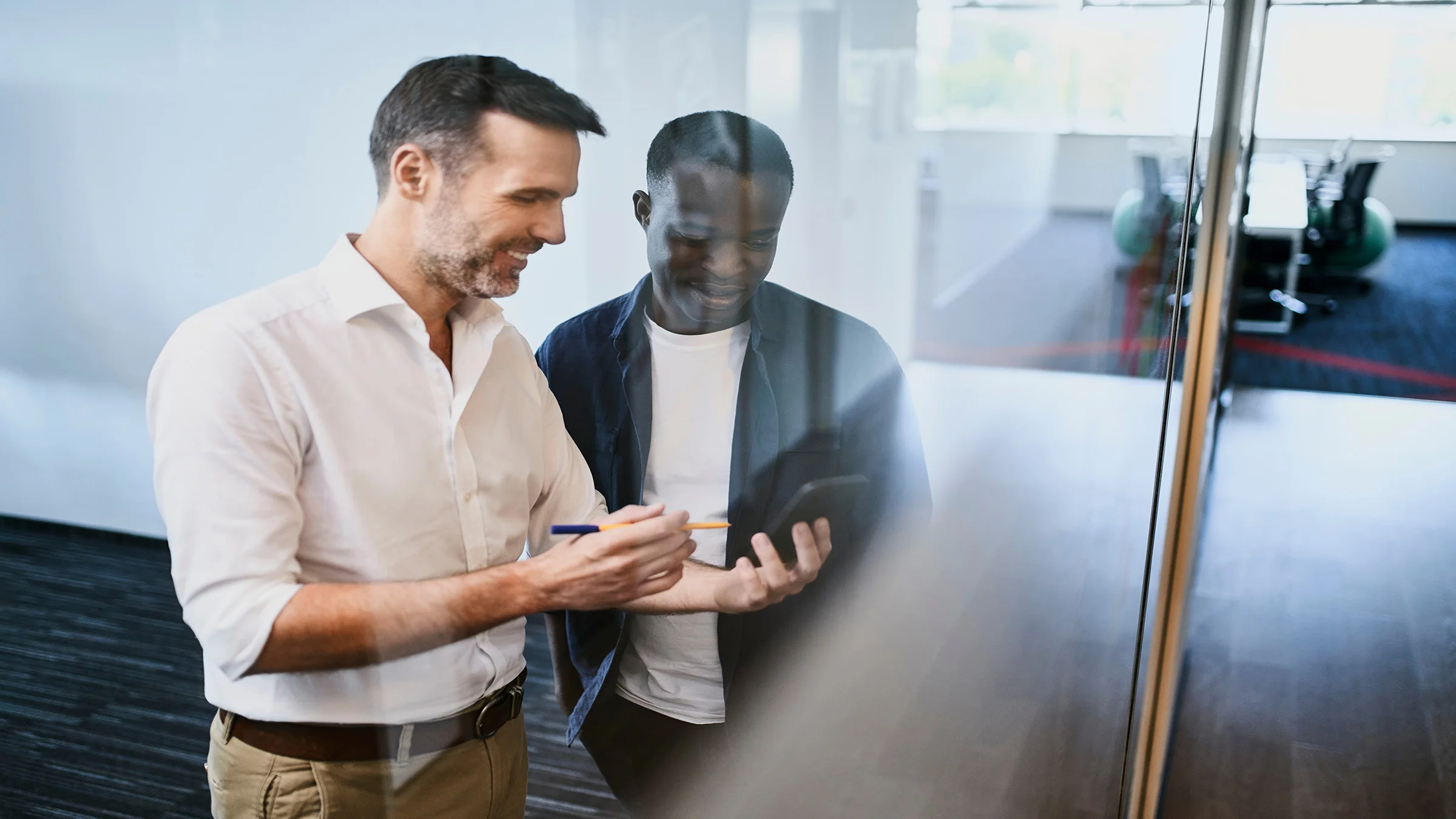 2 business men talking over a cell phone