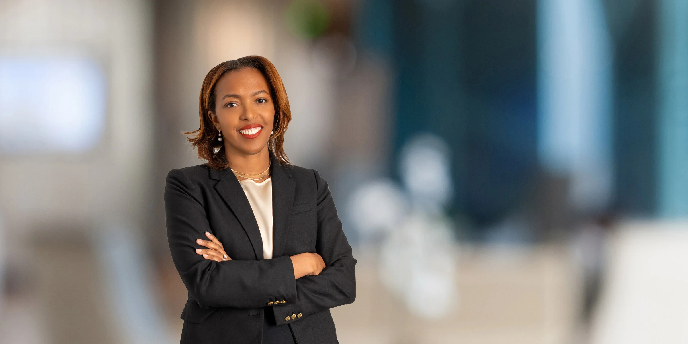 Smiling Jessica Gray in a dark suit with her arms crossed
