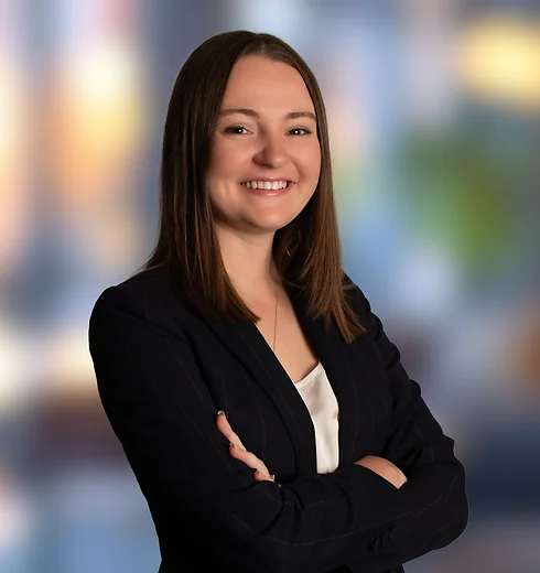 Kelsey Kita standing in a suit with her arms crossed