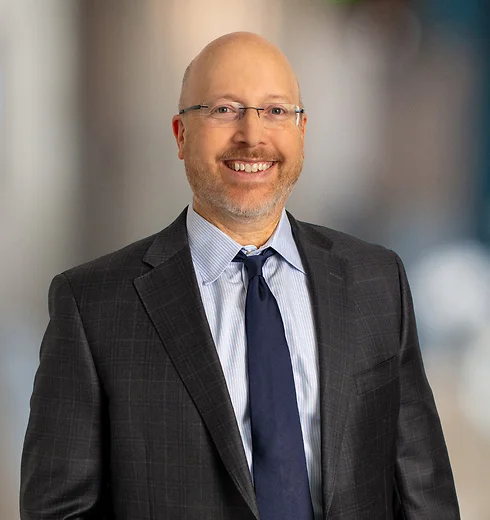 David Kamer in dark suit and navy tie