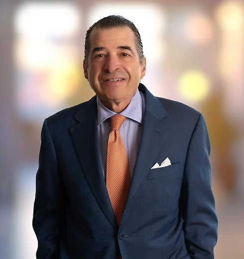 Ray Suttle wearing a blue suit and orange tie