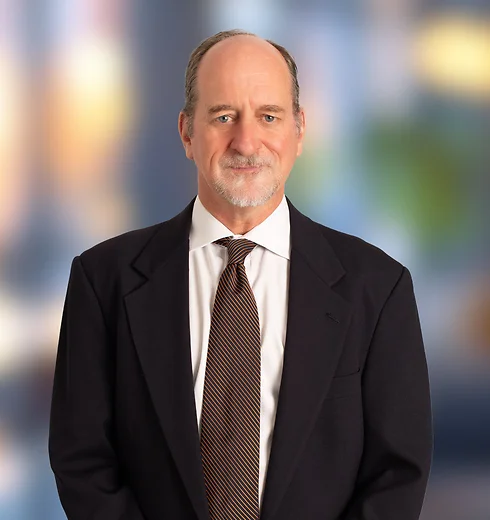 Lewis Webb wearing a dark suit and dark striped tie