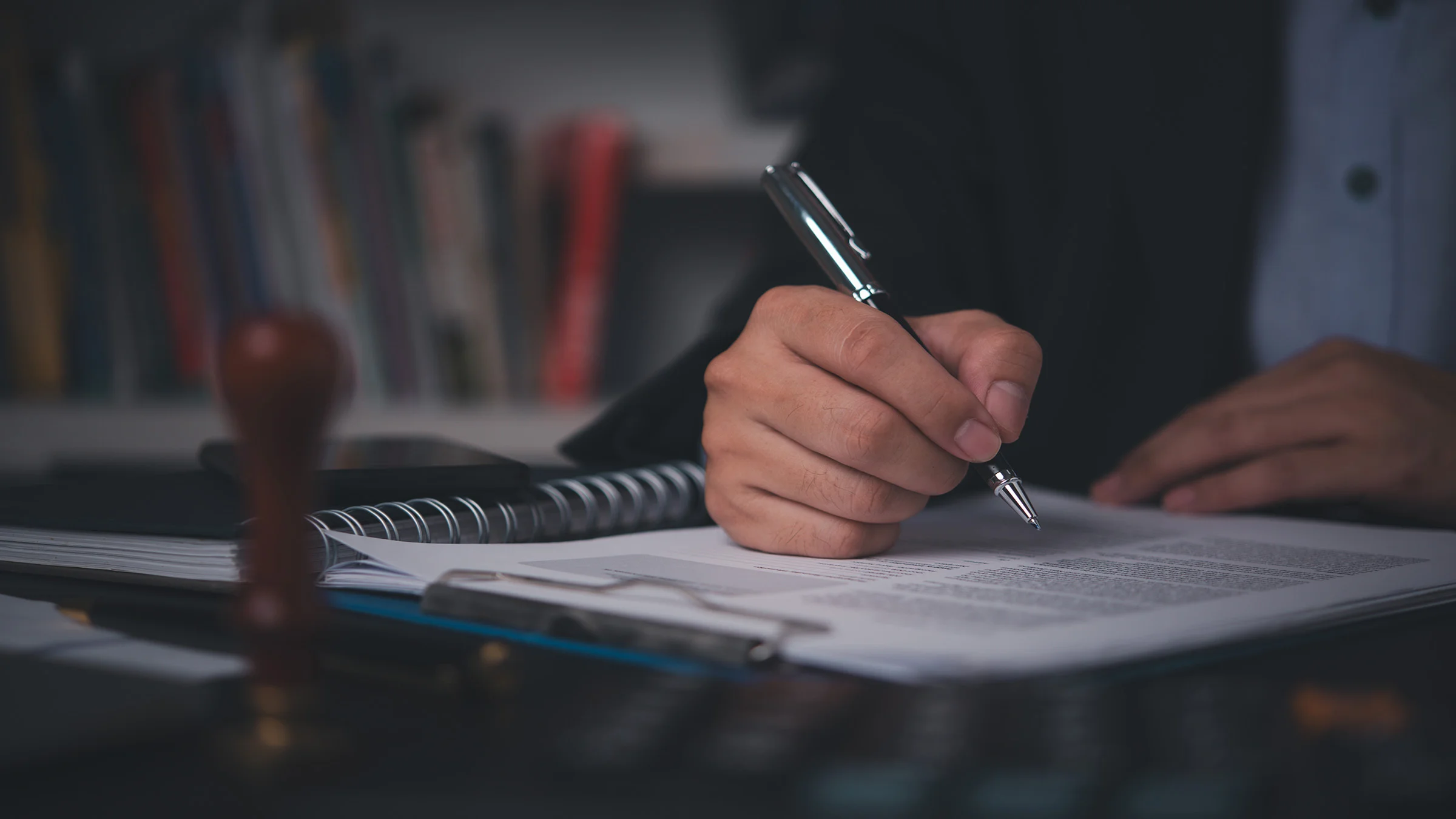 Man signing papers on desk