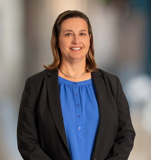 Kristan Burch standing in a blue shirt and black jacket
