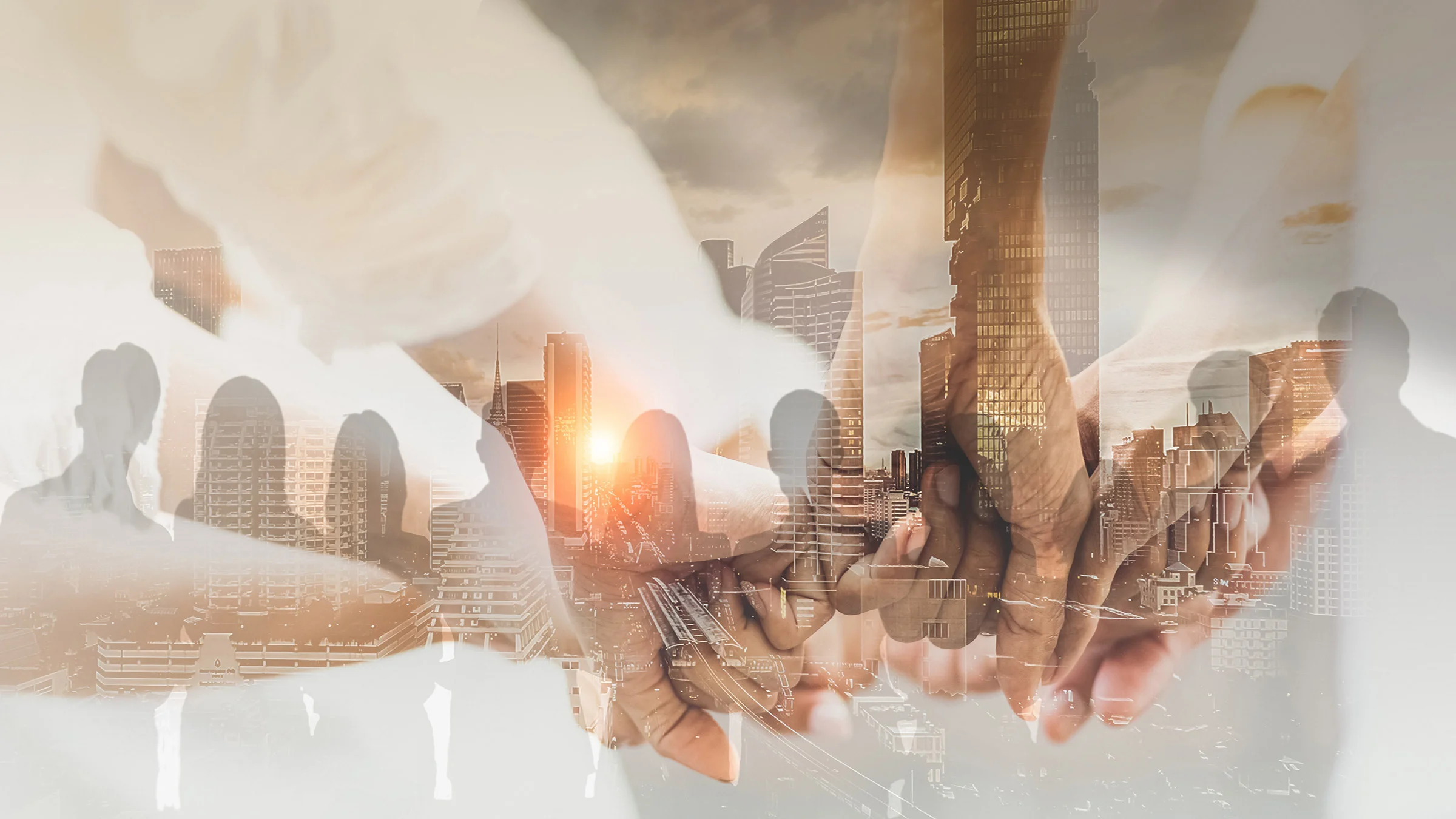 Double exposure image of buildings and a line of people holding hands