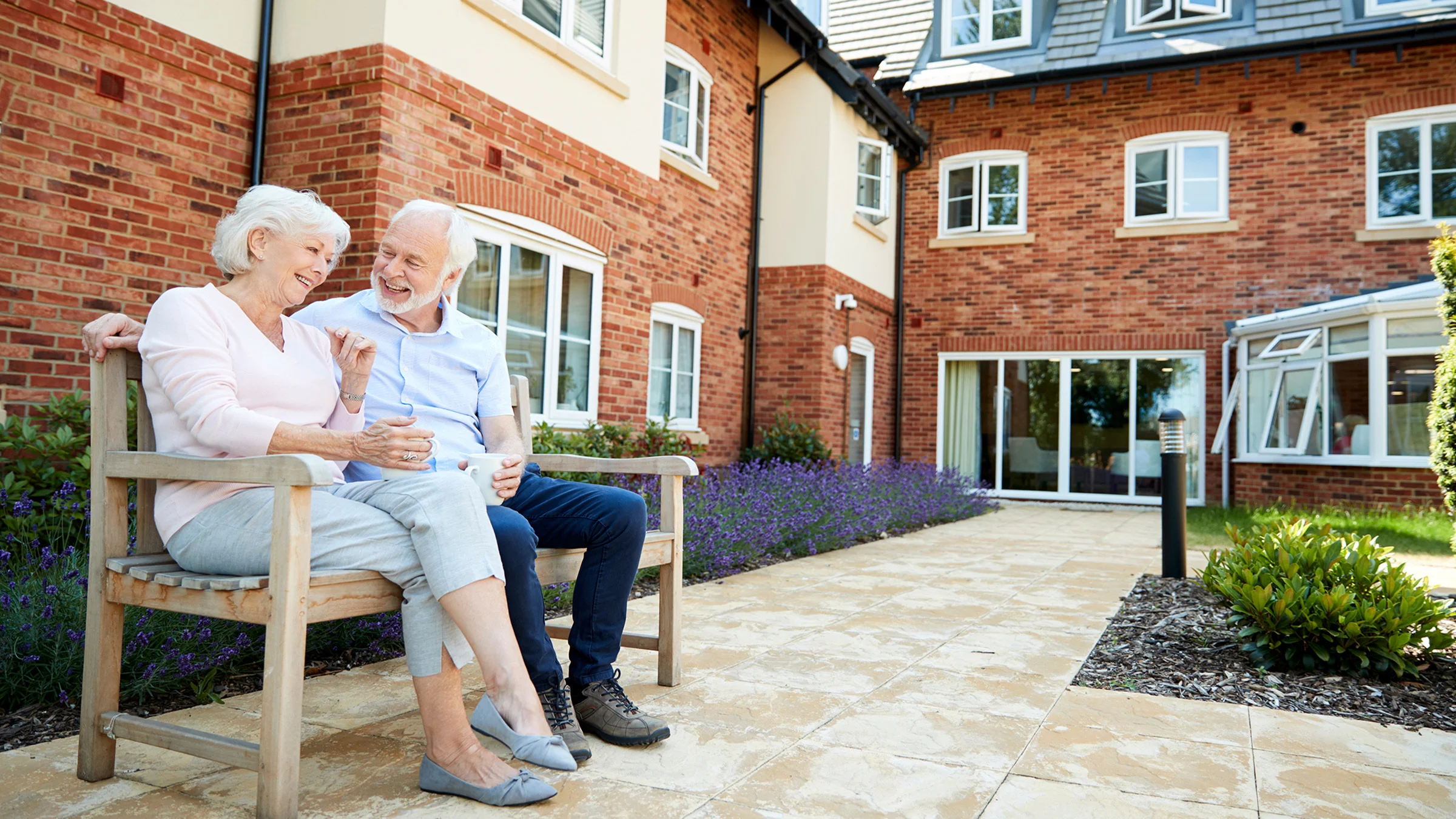 Senior couple on bench outside of senior housing community