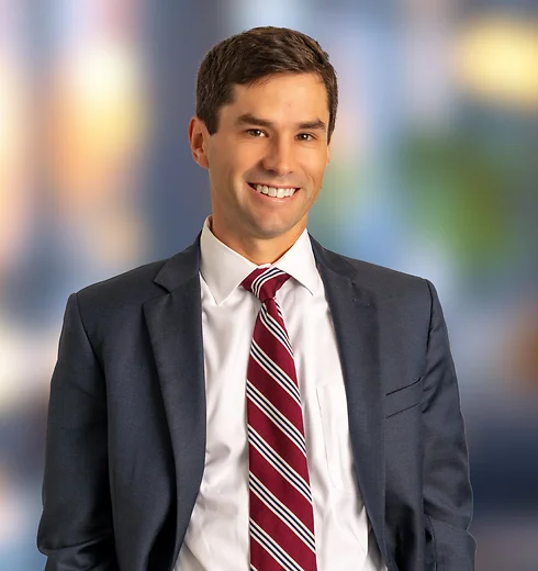 Clark Belote in a suit with his hands in his pockets