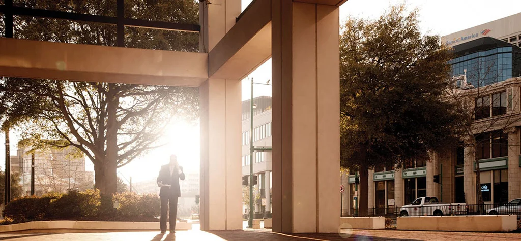 Man standing in a walkway in the sunshine