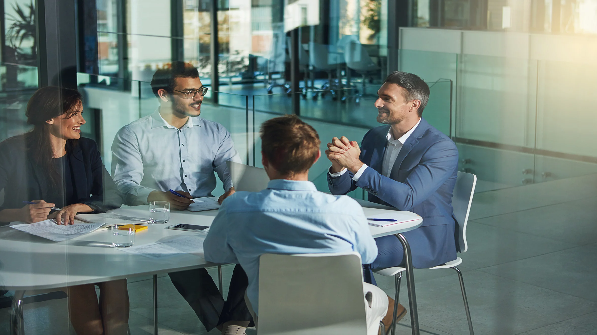 4 people around a conference room table talking
