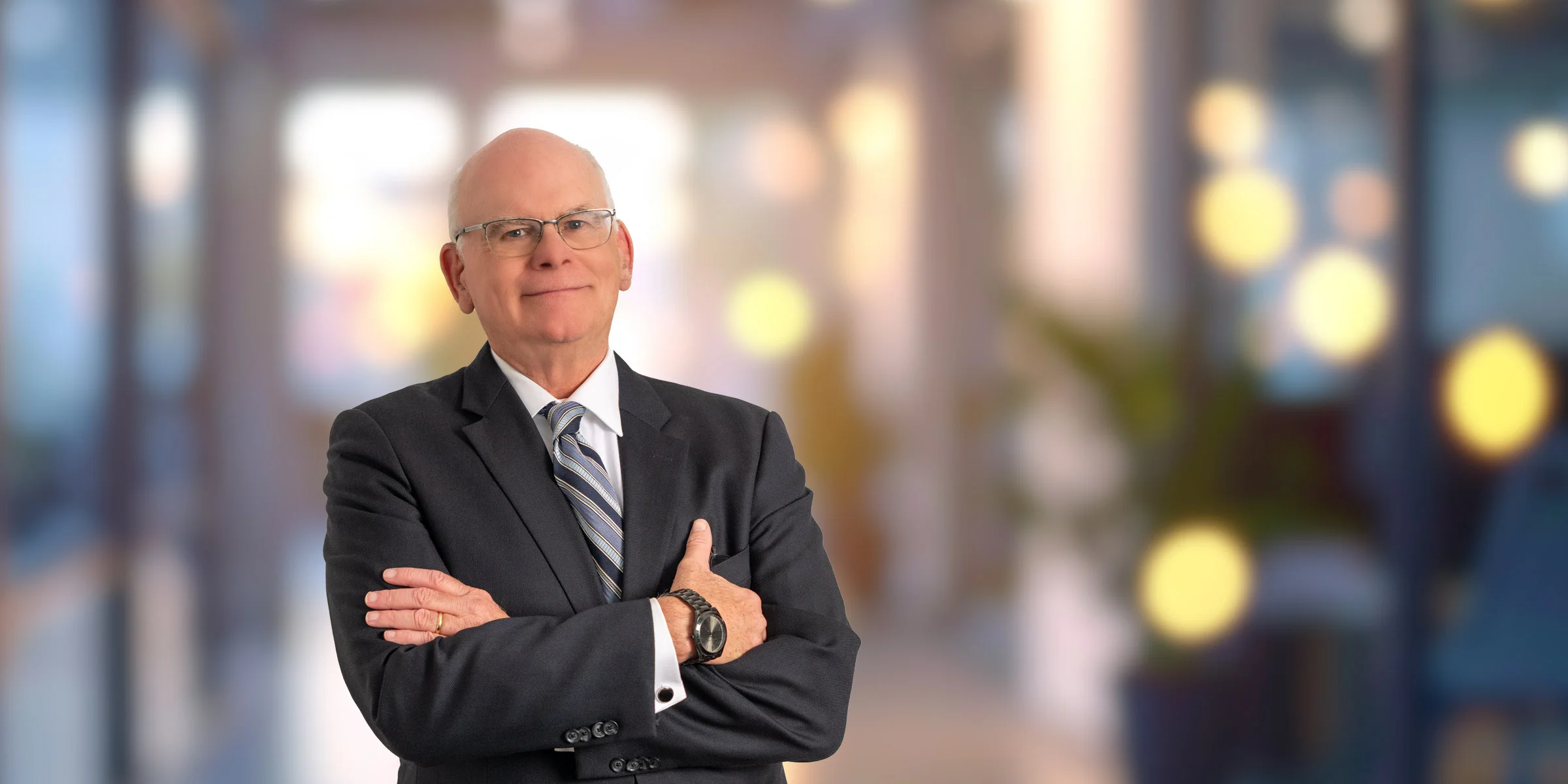 John Holloway in dark suit and striped tie