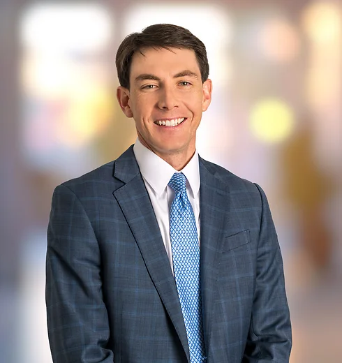 Daniel Yates in plaid suit jacket and blue patterned tie