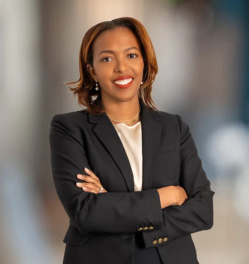 Smiling Jessica Gray in a dark suit with her arms crossed