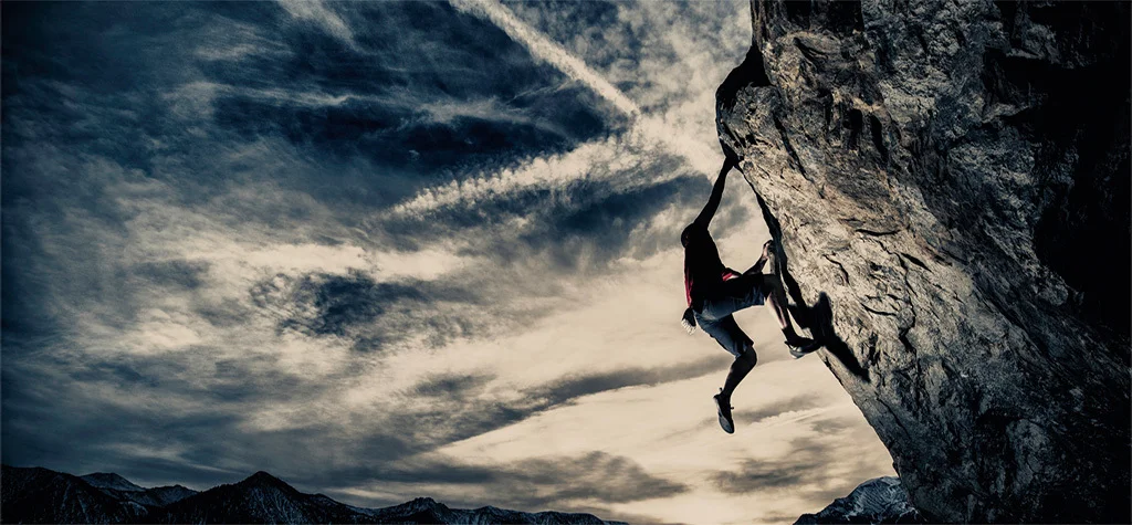 Rock climber hanging off cliff