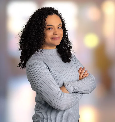 Journey Matos in a light blue sweater with her arms crossed