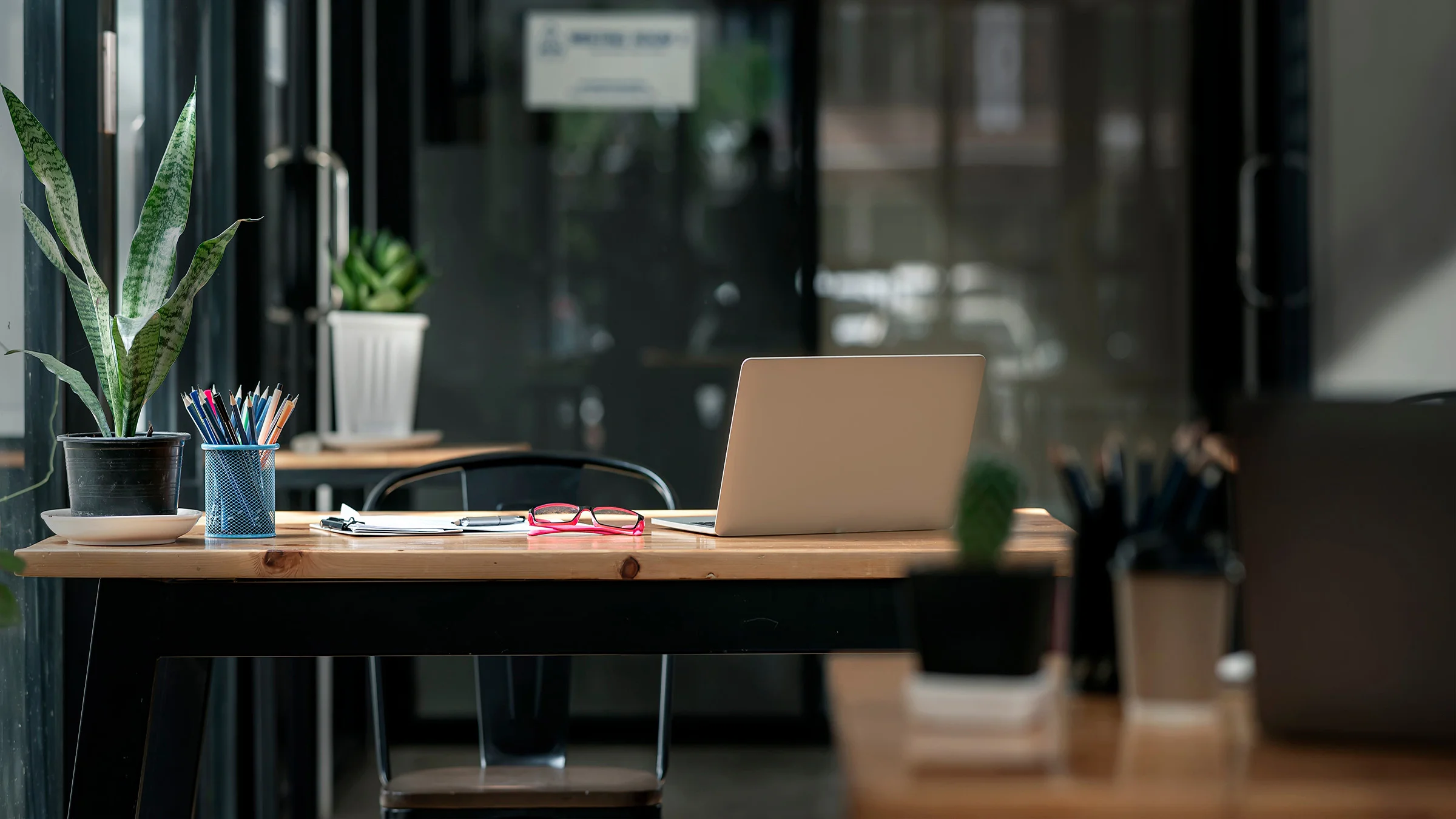 Empty office with pink glasses on the desk