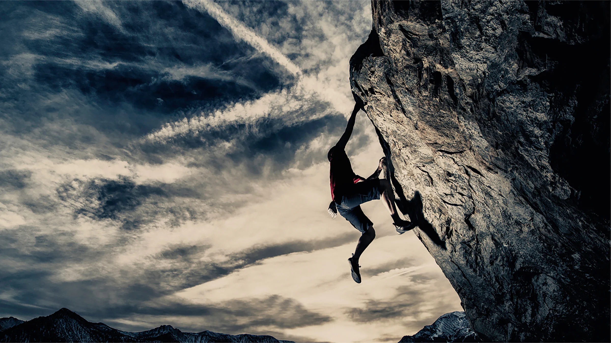 Cliff climber handing from cliff edge