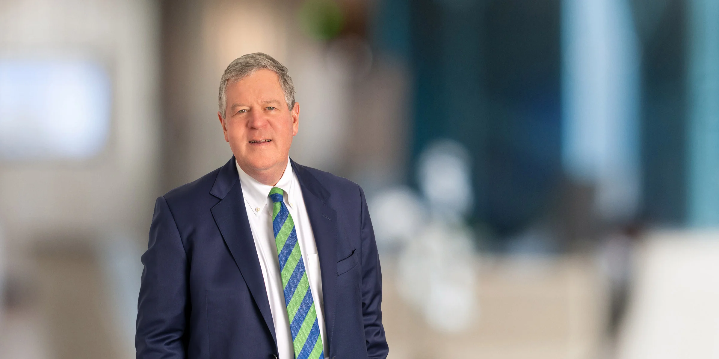 Charles McPhillips in a navy suit and green and blue striped tie