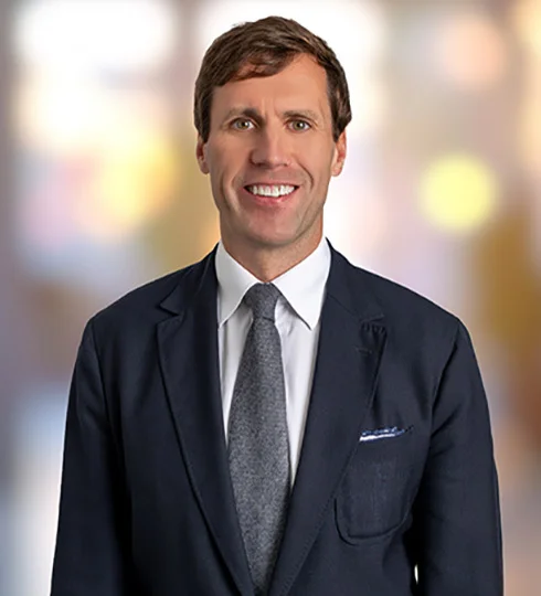 Smiling Britton Williston in a suit with his arms crossed