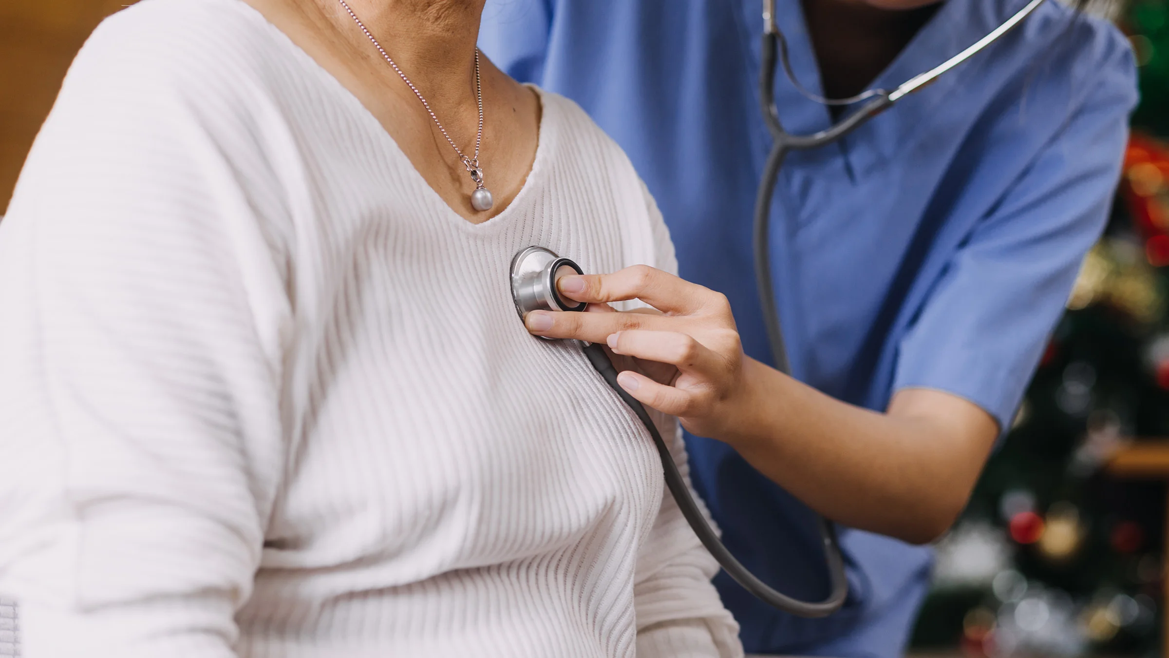Doctor holding stethoscope to patient's chest