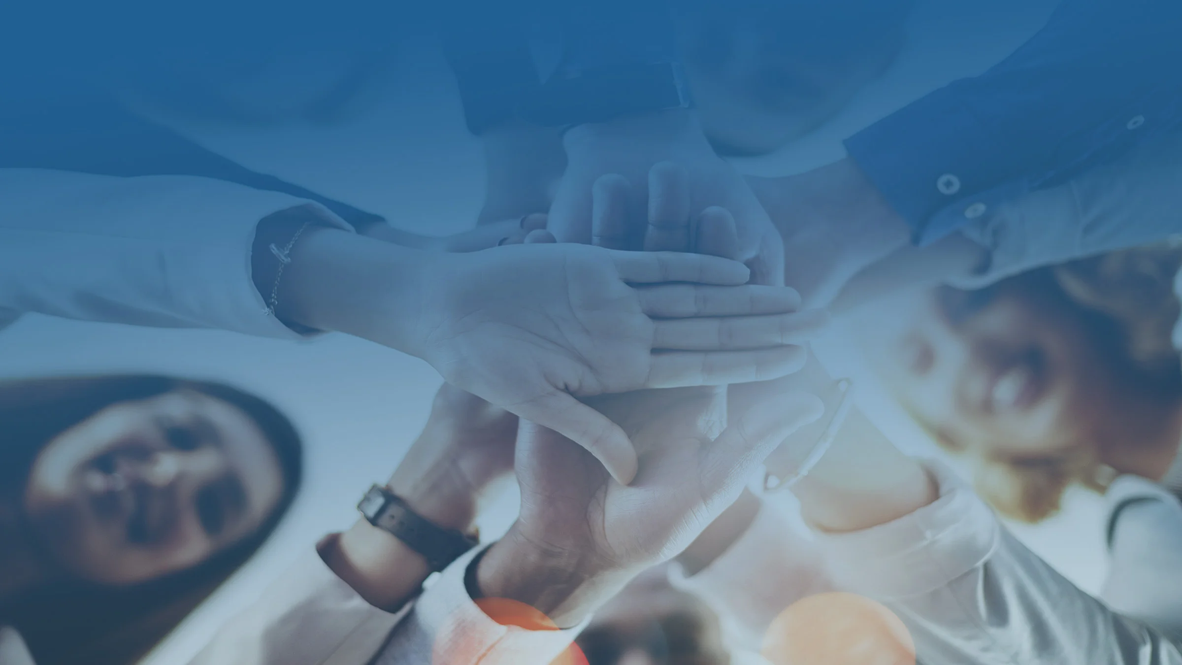 Group of people with their hands in the middle of a circle